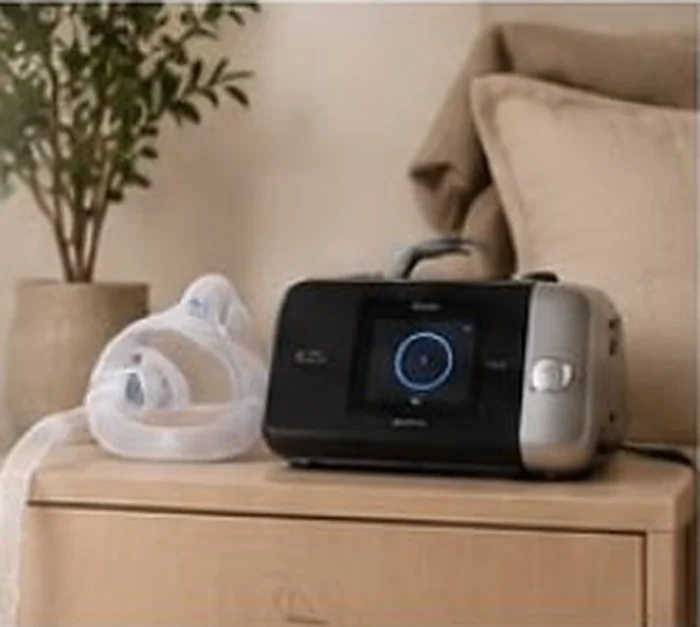 CPAP machine and mask on a wooden bedside table